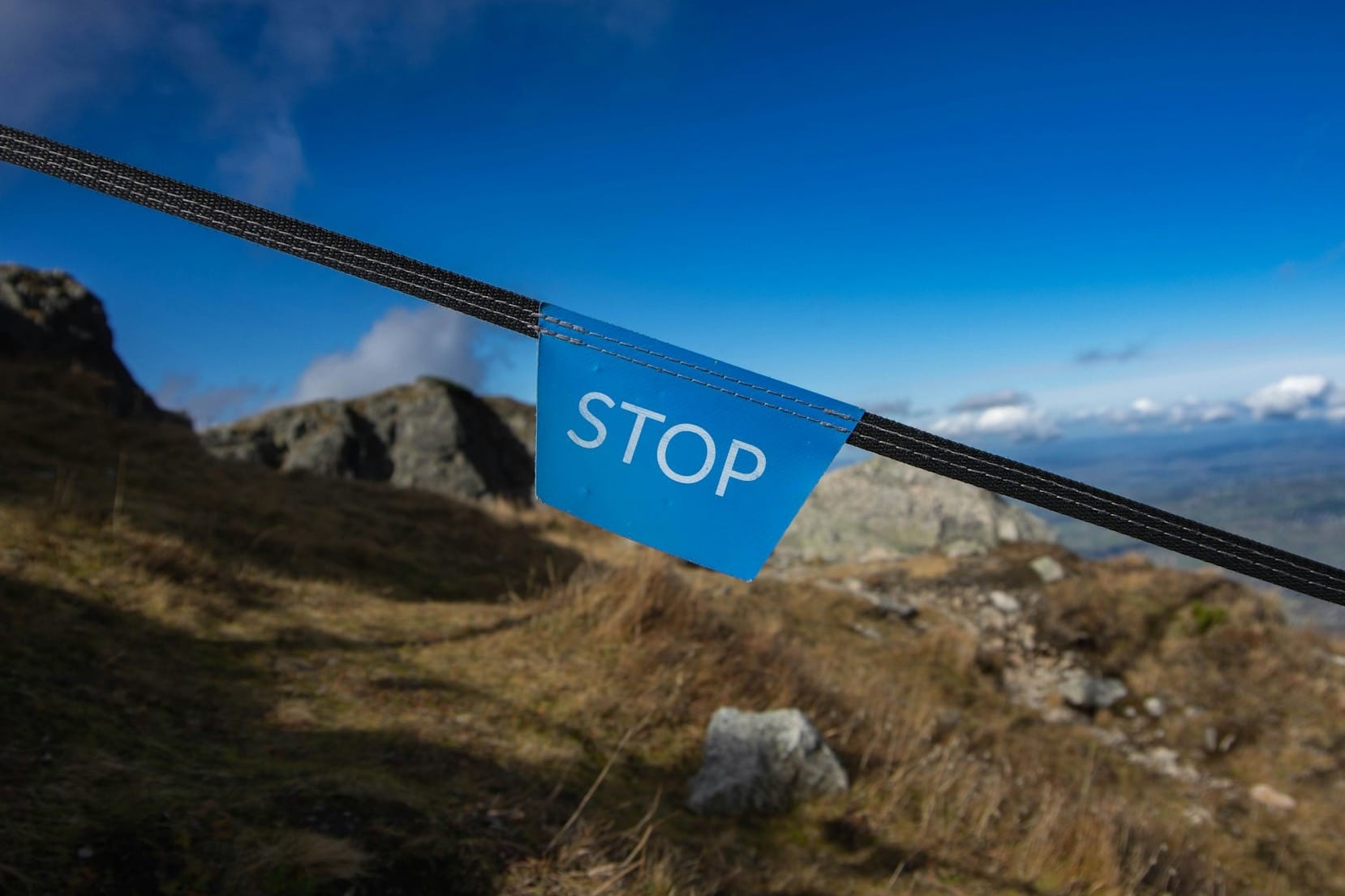a blue sign is hanging on a rope